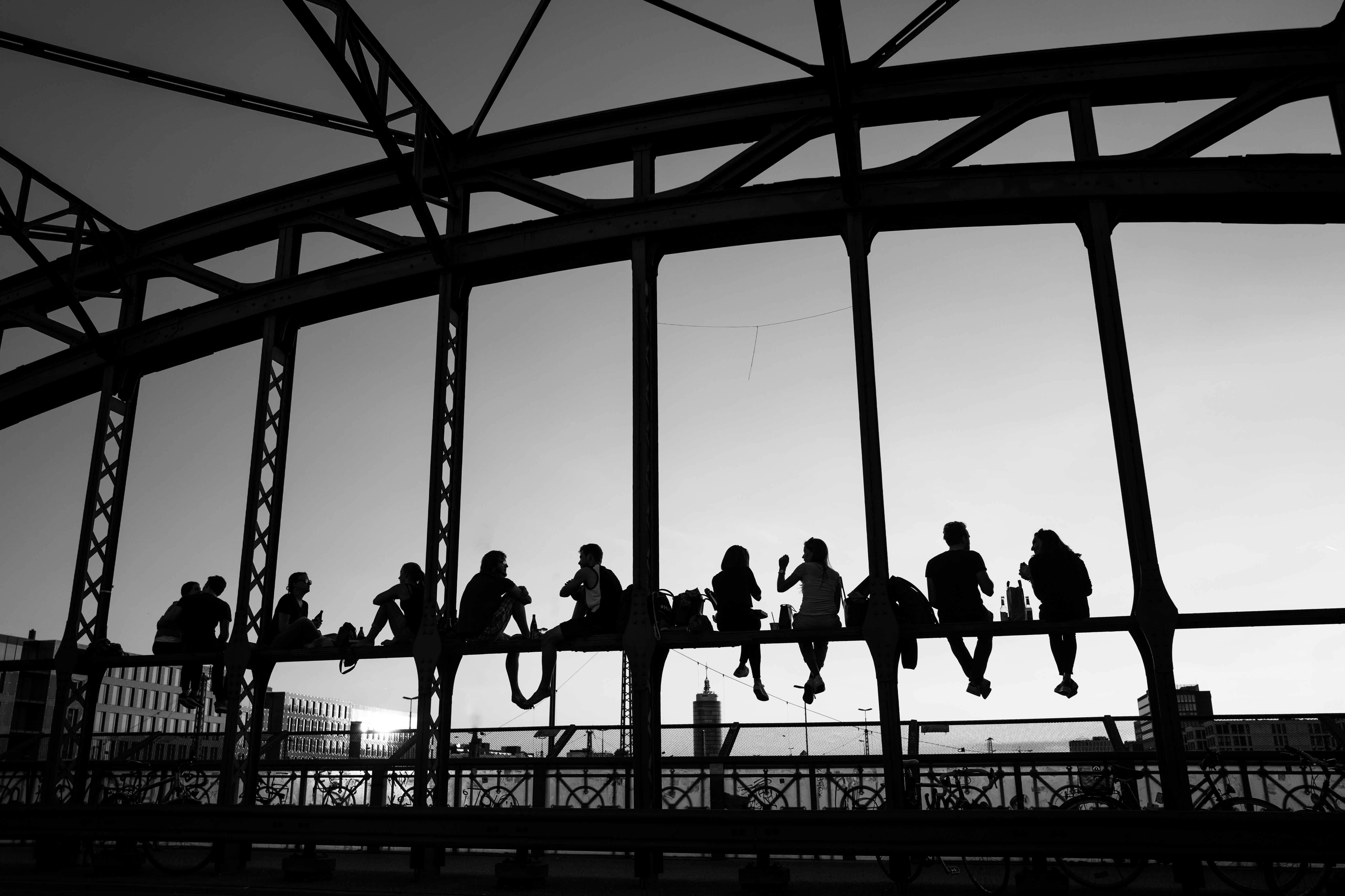 Ein Schwarzweiss-Bild auf dem Menschen mit Freunden auf einer Erhöhung der Hackerbrücke sitzen