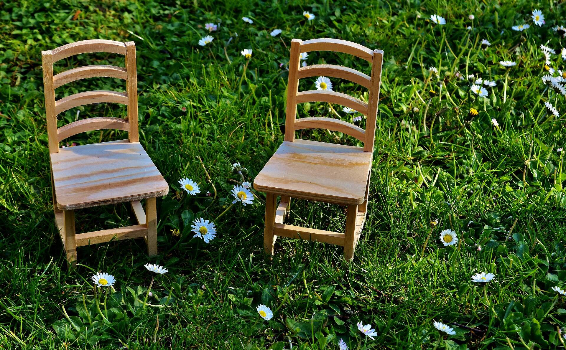 Zwei Stühle stehen auf einer Wiese und können beim Yoga auf oder mit dem Stuhl genutzt werden